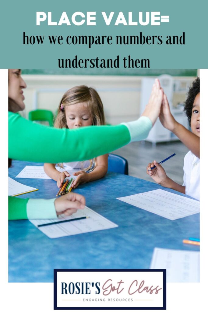 teacher giving a high-five to a student in a small group working to compare numbers