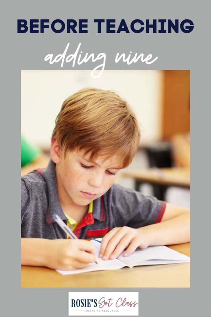 boy at a desk writing answers to addition problems